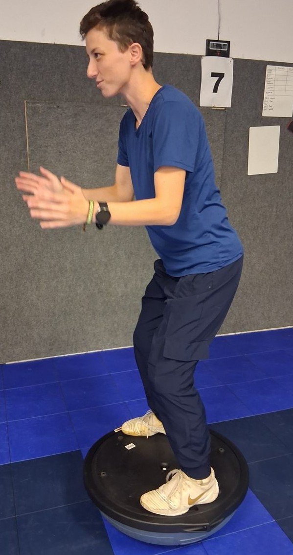 Dion balancing in a half squat on a balance trainer